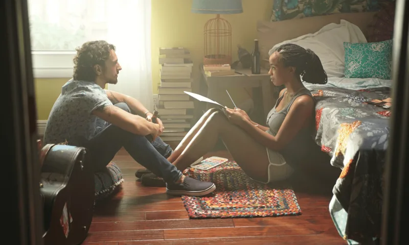 Two people sitting together on the floor of a warmly lit room