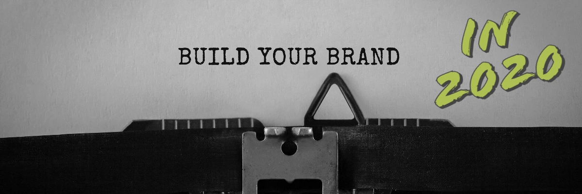 Typewriter with paper typed "Build your brand" and green "In 2020" lettering in the corner.